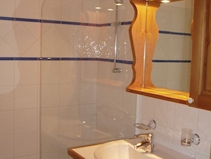 A bathroom with a wooden-framed mirror, a sink, and a shower. - Spacious apartment - 8 guests ski-in/ski-out (Les Menuires)