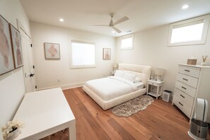 A bedroom with a bed, bedside tables, a desk, a dresser, and a ceiling fan. - Modern 6 Bedroom Northern VA/DC Dream Home! +Gym + Pool + Theater + Playroom (McLean)