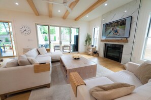 Ein modernes Wohnzimmer mit Sofa, Couchtisch und Kamin.