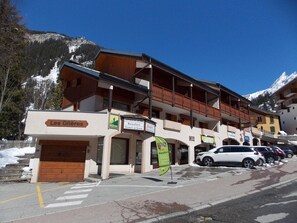 A multi-story building with a wooden facade, a ground-level shop named 'Les Glières,' and a sign for 'Beaufort' indicating a cooperative bakery. - Apartment in the heart of the resort - 6 guests (Pralognan-la-Vanoise)
