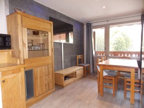 A wooden kitchen with a built-in microwave, a bench, and a dining table with chairs. - Apartment in the heart of the resort - 6 guests (Pralognan-la-Vanoise)