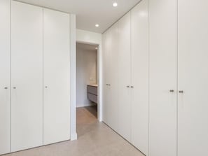 A hallway with white wardrobes and a visible bathroom with a sink. - Seaside residence, pets welcome (Estepona)
