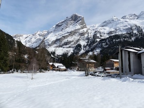 Eine verschneite Berglandschaft mit Gebäuden und geparkten Autos.