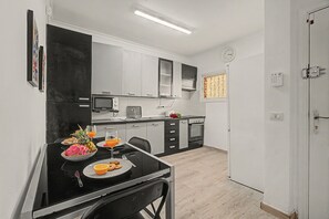 Una cuina moderna amb zona de menjador, equipada amb microones, torradora i forn.