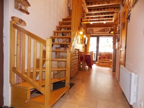 Eine Holztreppe führt zu einem Essbereich mit Ausblick ins Freie.
