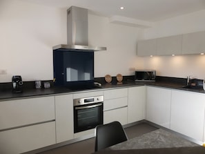 A modern kitchen with a built-in oven, microwave, and a stainless steel range hood. - Bright apartment with parking - 4 guests (Pralognan-la-Vanoise)