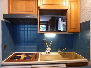 A kitchen with a stove, microwave, and sink. - Convenient apartment near the slopes - 6/8 guests (Pralognan-la-Vanoise)