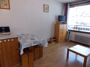A room with a bed, a wooden desk, a television on a cabinet, and a window with a view. - Studio in the heart of Pralognan - 4 guests (Pralognan-la-Vanoise)