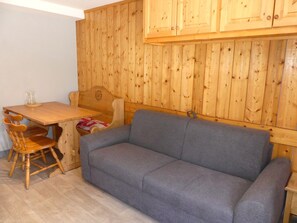 A wooden interior with a sofa, a wooden table, and a chair. - Central studio cabin, pets welcome - 4 guests (Pralognan-la-Vanoise)