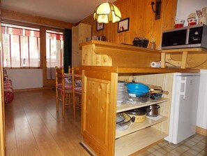 Eine Küche mit Holzausstattung, einer Mikrowelle und einem Kühlschrank.