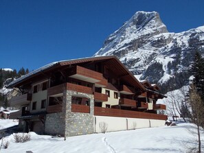 A chalet-style building with multiple balconies, set against a backdrop of snow-covered mountains. - 3-star duplex - 4 guests (Pralognan-la-Vanoise)