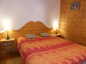 A wooden room with a bed, two nightstands, and two lamps. - Convenient apartment - 6 guests (Pralognan-la-Vanoise)