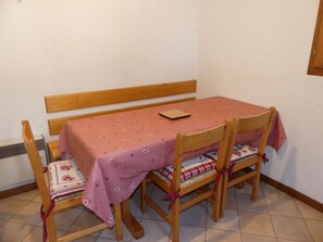 A small dining area with a table and four chairs, each with a checkered tablecloth. - Cozy duplex near slopes - 6 guests (Pralognan-la-Vanoise)