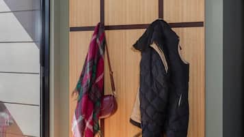 A room with a built-in wardrobe, a bench, and a window.