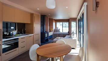 Una cocina moderna con comedor, estufa integrada y un amplio ventanal.