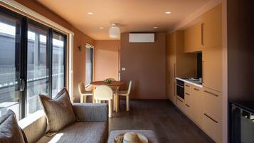 A compact living space with a sofa, dining table, and kitchenette.
