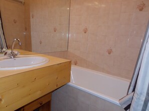 A bathroom with a wooden vanity, a white sink, and a bathtub. - Practical apartment 6 guests - Pralognan-la-Vanoise (Pralognan-la-Vanoise)
