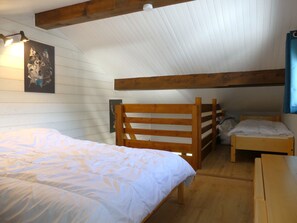 A room with a bunk bed, a single bed, wooden beams, a white ceiling, and a framed picture on the wall. - Mezzanine studio, pets allowed - 5 guests. Mountain view (Pralognan-la-Vanoise)