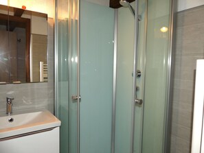 A bathroom with a glass-enclosed shower, a sink with a mirror above it, and tiled walls. - Mezzanine studio, pets allowed - 5 guests. Mountain view (Pralognan-la-Vanoise)