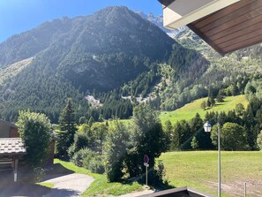 Blick auf Berge bei klarem Himmel, eine gepflasterte Auffahrt und ein Verbotsschild.