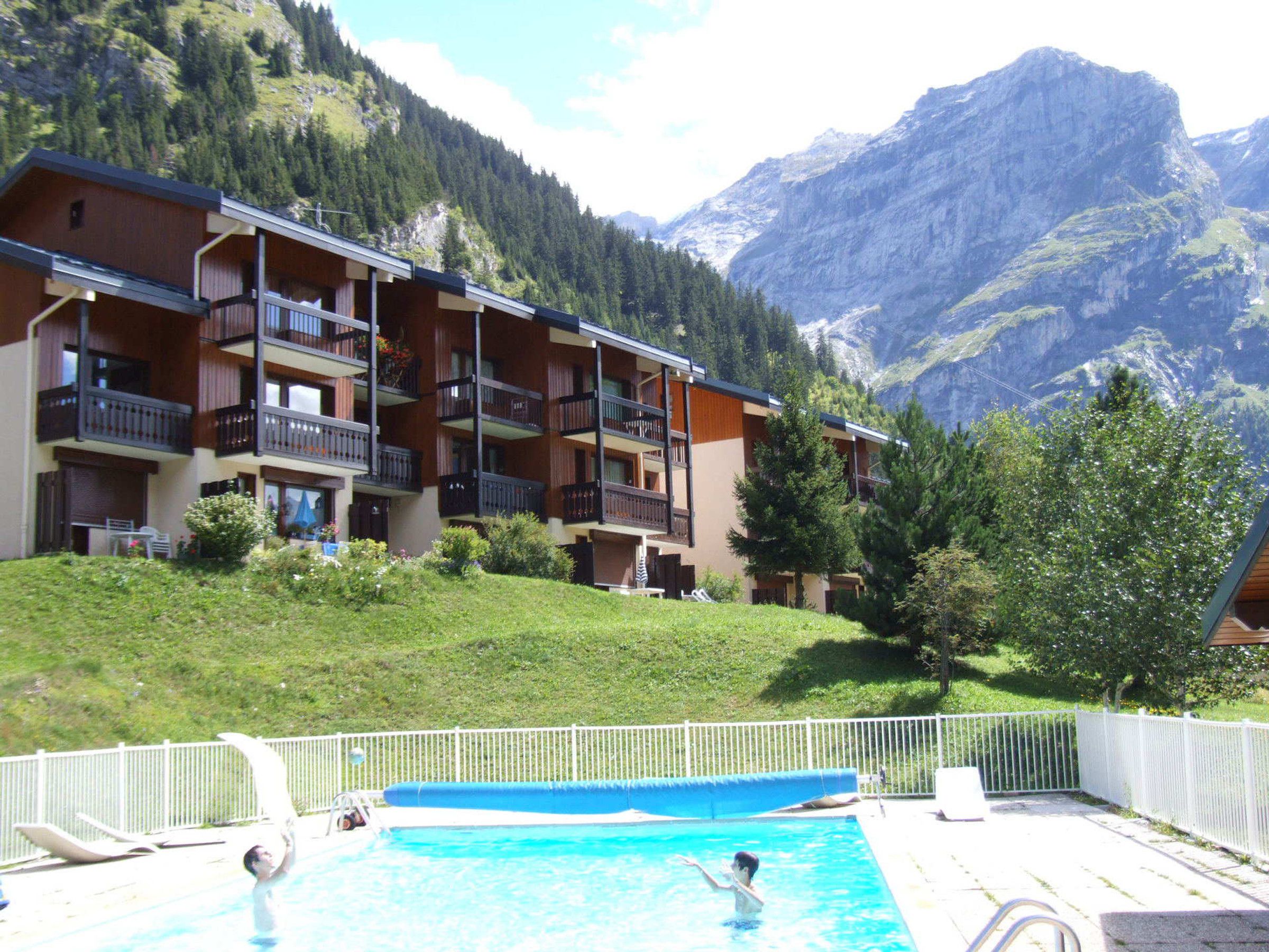 Un hotel con piscina, rodeado de montañas y vegetación.