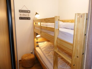 Ein Schlafraum mit Etagenbetten, einem Schild an der Wand und einer Lampe.