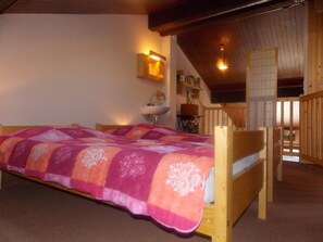 A bedroom with a wooden bed, a bedside lamp, and a view of a balcony. - Perfectly located apartment - 4 guests (Pralognan-la-Vanoise)