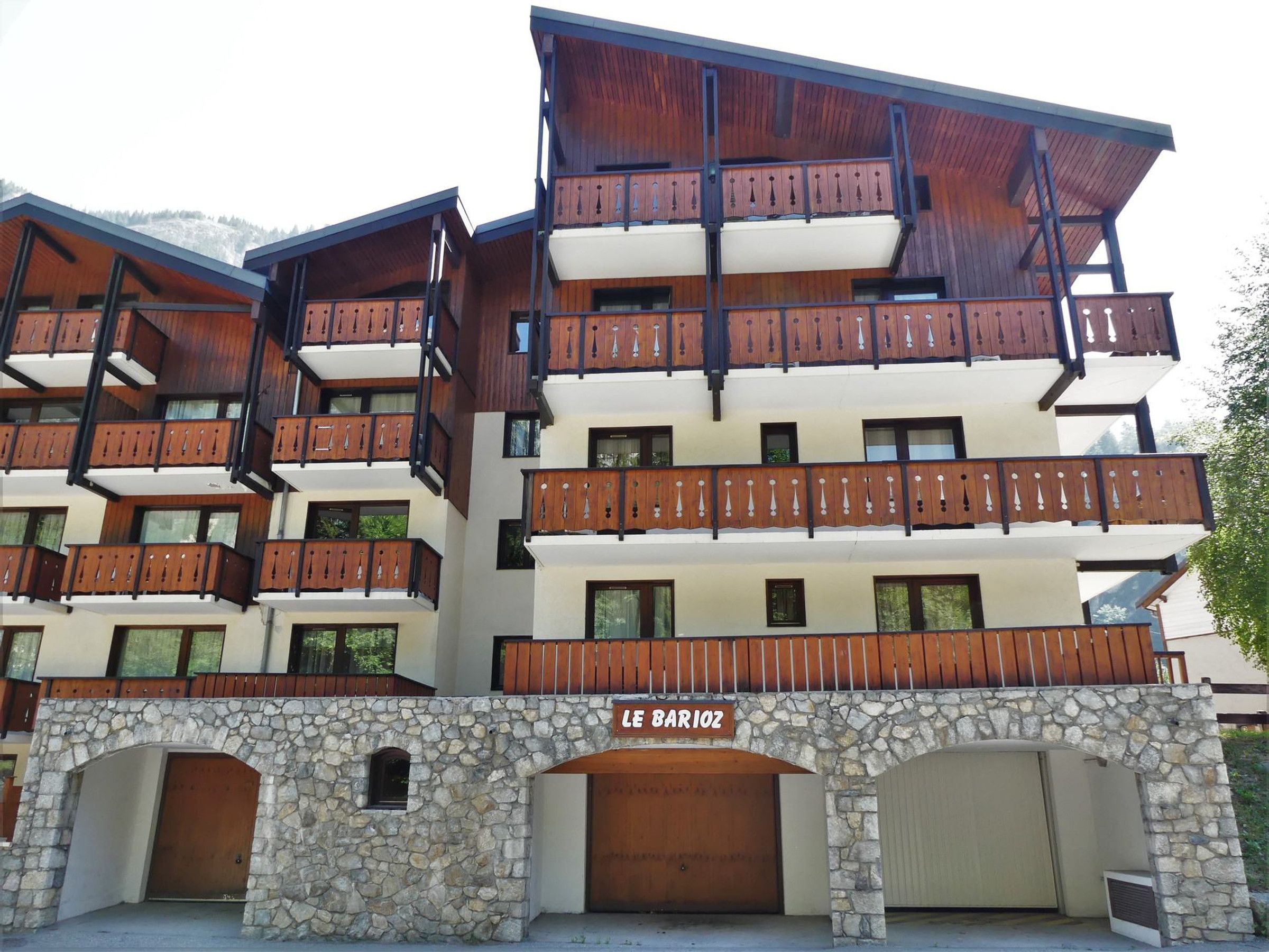 A multi-story building with balconies and a stone facade.