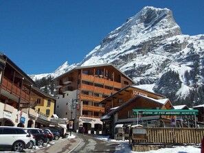 A snow-covered mountain town with a prominent hotel featuring balconies and a mountain view. - Comfortable apartment - 7 guests (Pralognan-la-Vanoise)