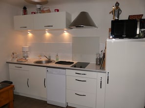 A modern kitchen with white cabinetry, a dishwasher, a coffee maker, and a microwave. - Spacious chalet - 4 guests (Pralognan-la-Vanoise)