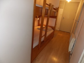 A narrow hallway with wooden bunk beds, a door, and a white wall. - Duplex at the foot of the slopes - 4 guests (Pralognan-la-Vanoise)