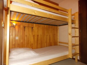 Ein Stockbett mit Holzgestell und einer Metallleiter.