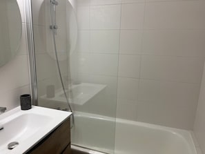 A bathroom with a glass-enclosed shower, a white sink, and a mirror. - Apartment in exclusive area - 4 guests (Pralognan-la-Vanoise)