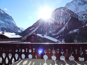 Berglandschap met een houten chalet en een balkon met hangende verlichting.