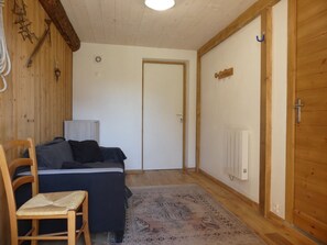 A room with a bed, a chair, a radiator, and a door. - Renovated house at the slopes - 5 guests (Pralognan-la-Vanoise)