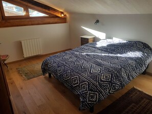 A bedroom with a bed, a radiator, a window, and a nightstand. - Renovated house at the slopes - 5 guests (Pralognan-la-Vanoise)