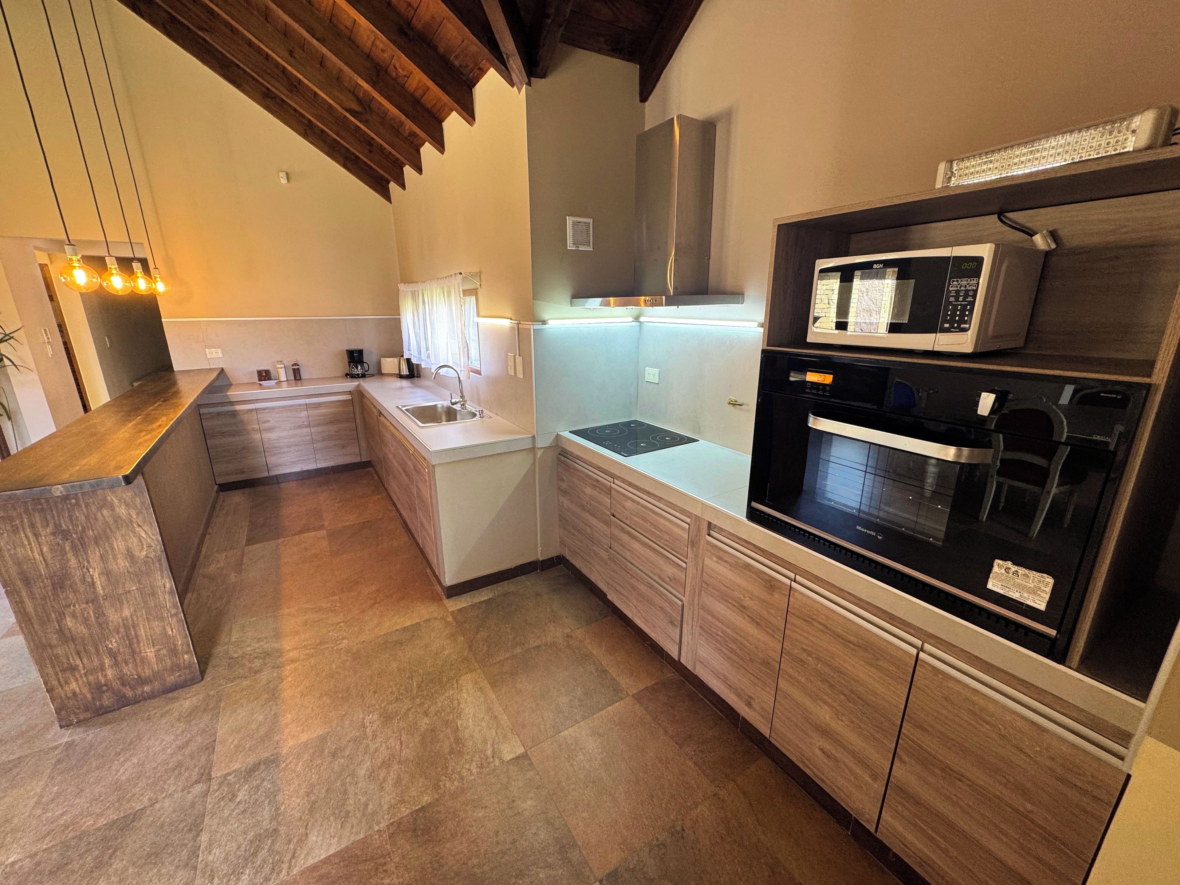 A modern kitchen with a built-in oven, microwave, and sink.