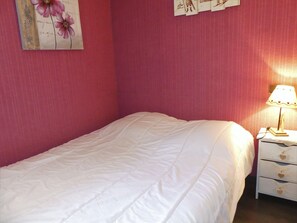 A single bed with a white bedspread in a room with pink walls. - Sunny apartment - 4 guests (Pralognan-la-Vanoise)
