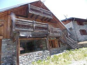 A wooden chalet with a stone foundation, a balcony, and a stone staircase. - Chalet, pets allowed - 8 guests in quiet area (Pralognan-la-Vanoise)