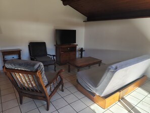 A room with a sofa, a wooden chair, a small table, a television, and a cabinet. - Balcon du Pontillas, garden, ski/bike storage, 400 m from slopes, shuttle 100 m (La Salle-les-Alpes)