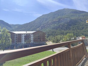 A hotel with multiple floors, a balcony, and a mountainous backdrop. - Balcon du Pontillas, garden, ski/bike storage, 400 m from slopes, shuttle 100 m (La Salle-les-Alpes)