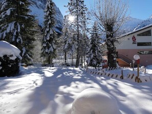 A snowy landscape with trees and a building with a red logo. - Quiet chalet - 6 guests (Pralognan-la-Vanoise)