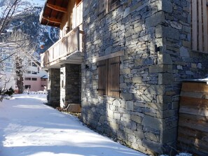 A stone building with a wooden balcony and a window, surrounded by snow. - Quiet chalet - 6 guests (Pralognan-la-Vanoise)