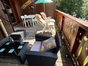 Eine Terrasse im Freien mit Korbmöbeln, einem Tisch und Stühlen.