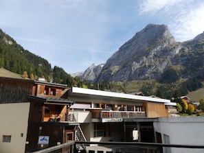 A hotel with a mountain view, wooden exterior, and a sign indicating a pharmacy. - Comfortable central studio - 4 guests (Pralognan-la-Vanoise)
