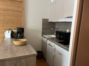 A compact kitchen with a coffee maker, toaster, and a microwave on the countertop. - Comfortable central studio - 4 guests (Pralognan-la-Vanoise)