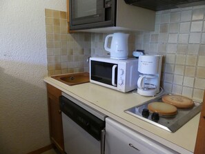 A compact kitchenette with a microwave, coffee maker, and a small sink. - Studio cabin, pets welcome - 4 guests (Pralognan-la-Vanoise)