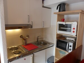 A compact kitchen with a stove, sink, and two microwave ovens. - Well-located studio cabin, cats OK - 4 guests (Pralognan-la-Vanoise)