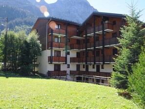 A multi-story building with balconies, surrounded by greenery and mountains. - Pleasant studio near slopes - 4 guests (Pralognan-la-Vanoise)