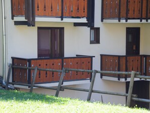 Un immeuble à plusieurs étages doté de balcons et d’une clôture en bois.